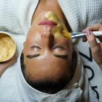 A woman enjoying a gold facial mask for relaxation and skincare at a spa.